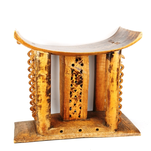 1354 - A large Ashanti Chief's stool, carved from a single piece of timber, with pierced decoration, probab... 