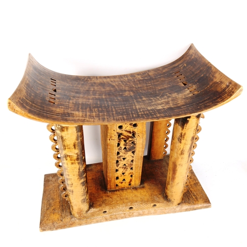 1354 - A large Ashanti Chief's stool, carved from a single piece of timber, with pierced decoration, probab... 