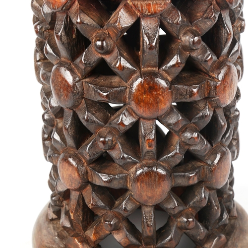 1355 - A small African stained wood drum-shaped stool with lattice pierced carved side, carved from a singl... 