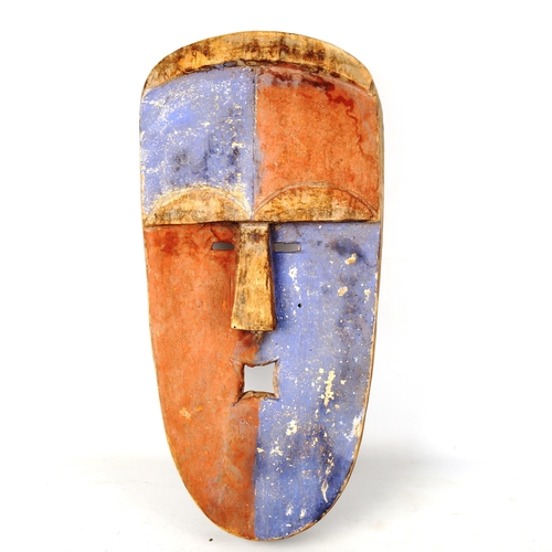 1356 - An African carved and painted wood flat-faced mask, with quartered blue and red decoration, length 4... 