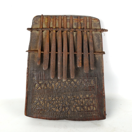 1359 - An early African Tribal piano, chip carved wood and metal, length 23cm