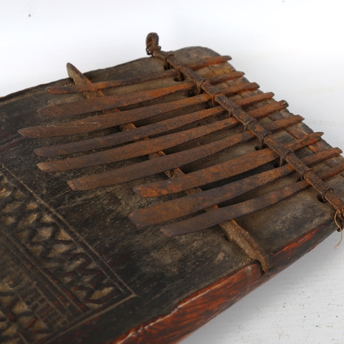 1359 - An early African Tribal piano, chip carved wood and metal, length 23cm