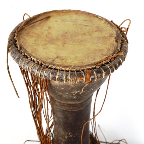 1360 - An African Tribal drum with sinew sides, height 40cm, diameter 20cm