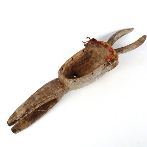 1364 - An African carved and painted wood lega horned mask, length 74cm