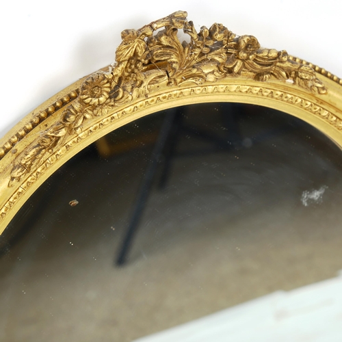 1380 - A circular Victorian gilt-gesso framed wall mirror, with floral pediment, height 54cm, width 46cm