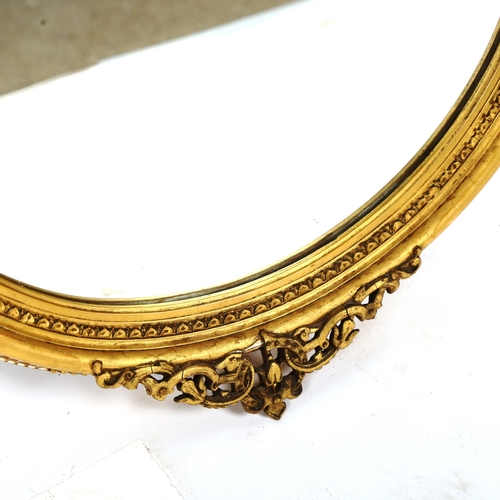 1380 - A circular Victorian gilt-gesso framed wall mirror, with floral pediment, height 54cm, width 46cm