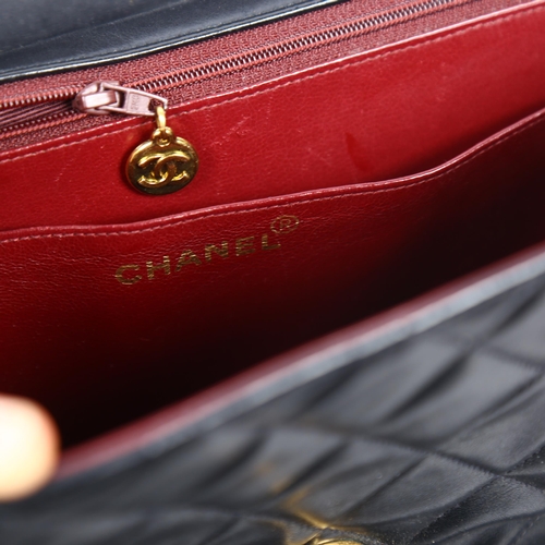 1388 - CHANEL - a Maxi Flap XL black lambskin handbag, with burgundy lining, serial no. 2864511, 1991, with... 