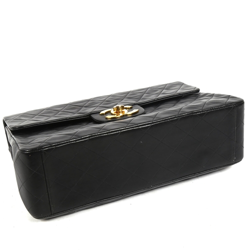 1388 - CHANEL - a Maxi Flap XL black lambskin handbag, with burgundy lining, serial no. 2864511, 1991, with... 
