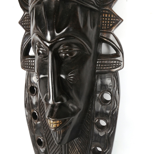 1433 - A large African carved ebonised wood mask, height 110cm