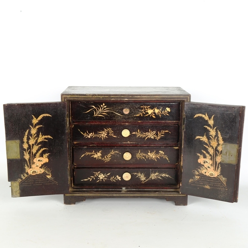 1441 - A Japanese gilded and ebonised table cabinet of small size, 2 doors enclosing 4 drawers, allover pai... 