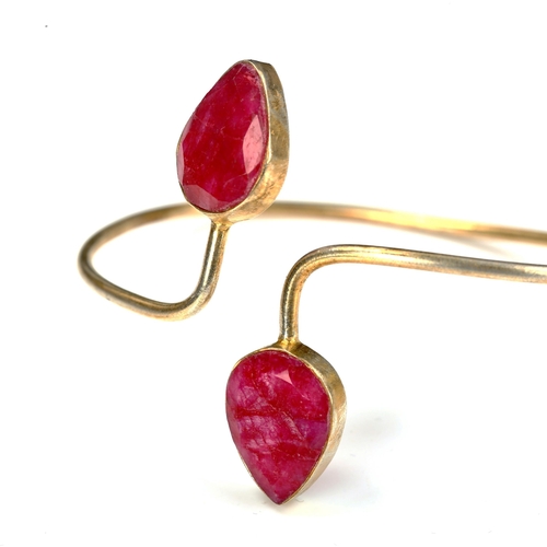 736 - A modern unmarked silver-gilt ruby torque bangle, internal measurements 6.5cm x 5cm, 12.1g