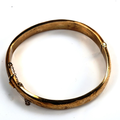 745 - A mid-20th century 9ct gold hinged bangle, engraved foliate decoration, maker's marks C and F, hallm... 