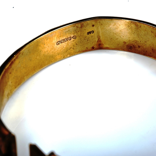 745 - A mid-20th century 9ct gold hinged bangle, engraved foliate decoration, maker's marks C and F, hallm... 