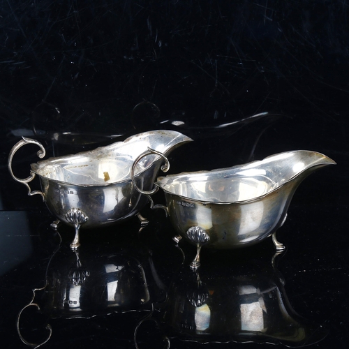 775 - A pair of George V silver sauce boats, with scalloped rims and C-shaped handles, maker's marks TS, h... 