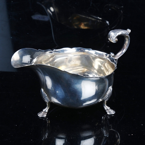 776 - An Edwardian Scottish silver sauce boat, with scalloped rim, scrolled acanthus leaf C-shaped handle ... 