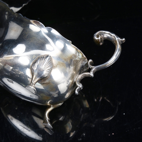 776 - An Edwardian Scottish silver sauce boat, with scalloped rim, scrolled acanthus leaf C-shaped handle ... 