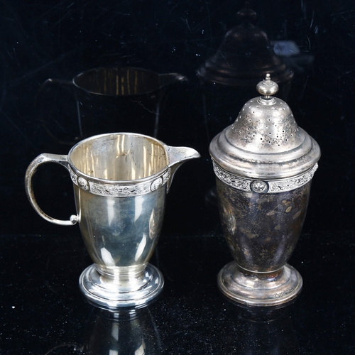 788 - An Elizabeth II silver matching pedestal cream jug and sugar shaker, with relief cast Gothic decorat... 