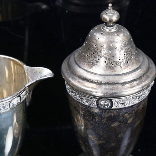 788 - An Elizabeth II silver matching pedestal cream jug and sugar shaker, with relief cast Gothic decorat... 