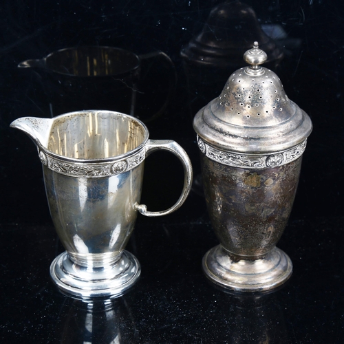 788 - An Elizabeth II silver matching pedestal cream jug and sugar shaker, with relief cast Gothic decorat... 