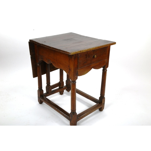 1415 - An unusual 18th century joined oak single drop leaf occasional table of small size, with single frie... 