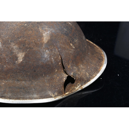 1223 - A military tin helmet with a sniper's bullet hole