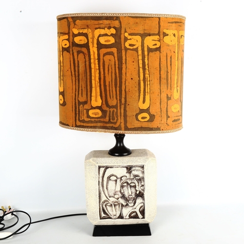 1887 - A mid-century tribal mask design ceramic lamp base with matching batik tribal faces shade, overall h... 