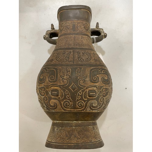 1006 - A Chinese Archaic style bronze vase, with relief decoration and dragon handles, height 30cm