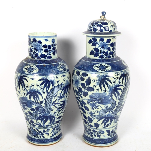 214 - A pair of Chinese blue and white 'Dragon' jars, height 37cm, and 1 lid (both chipped and cracked)