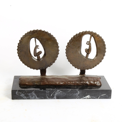 72 - A surrealist bronze sculpture, flexed arms within saw wheels, unsigned, on veined black marble base,... 