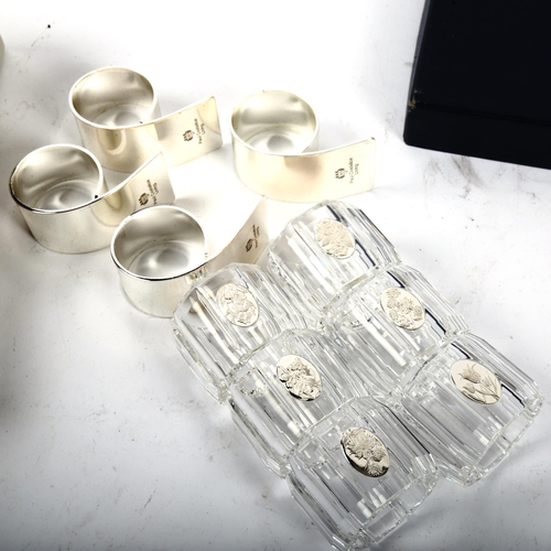 1020 - PAUL COSTELLOE - A set of 6 silver plated napkin rings, in original box, and a set of 6 glass napkin... 