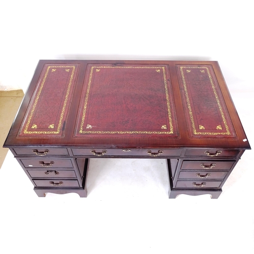 2029 - A reproduction mahogany veneered twin-pedestal writing desk, with a a 3-section red leather tooled t... 