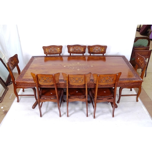 2048 - An Indian hardwood dining room table and 8 chairs, the table having floral carved edge with brass in... 