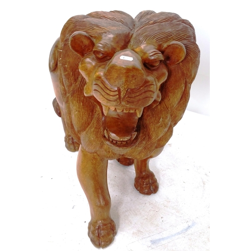 2050 - A carved hardwood study of a lion, length 90cm, H77cm