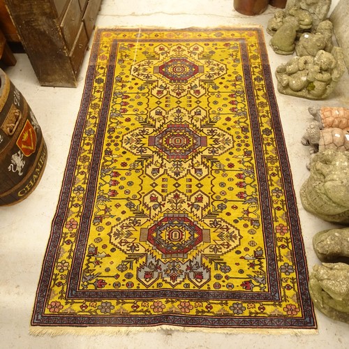 2799 - A yellow ground Afghan design rug, 208cm x 130cm