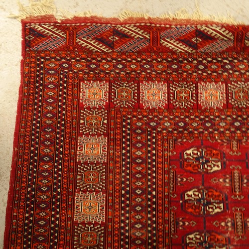 2800 - A red ground Afghan Tekke design rug, 270cm x 190cm