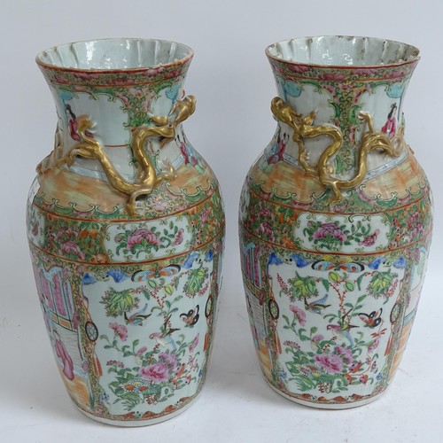 213 - A pair of Chinese Canton famille rose vases, with enamelled courtyard decoration, with applied gilde... 