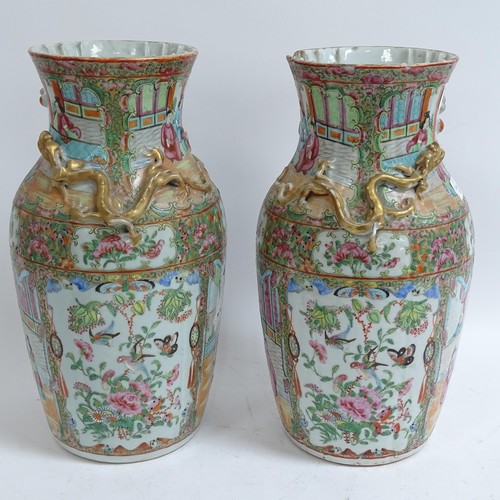 213 - A pair of Chinese Canton famille rose vases, with enamelled courtyard decoration, with applied gilde... 