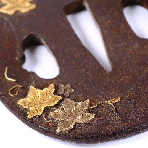 1019 - An Antique Japanese iron tsuba with parcel gilt relief vine leaves, length 6.5cm