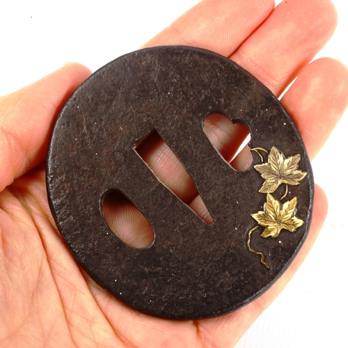 1019 - An Antique Japanese iron tsuba with parcel gilt relief vine leaves, length 6.5cm