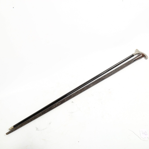 1067 - A 19th century walking stick, with unmarked white metal floral decorated handle, and a relief carved... 