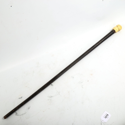 1069 - A carved ivory-handled walking cane, depicting the head of a man