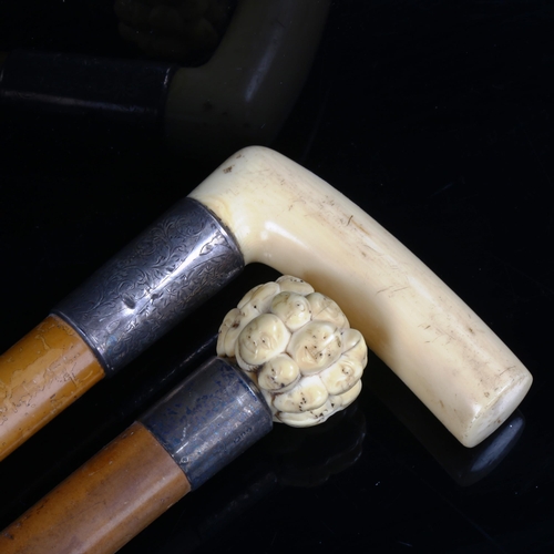 1071 - A Japanese ivory-handled netsuke, depicting man faces, and an ivory and silver-handled walking stick... 
