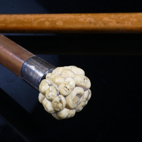 1071 - A Japanese ivory-handled netsuke, depicting man faces, and an ivory and silver-handled walking stick... 