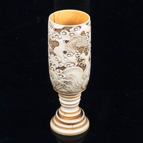 1085 - A Japanese ivory goblet circa 1900, the bowl relief carved with sea dragons, and ring turned base wi... 