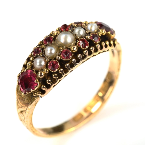 215 - A Victorian 15ct gold ruby and pearl half hoop ring, foliate engraved shoulders with closed-back set... 