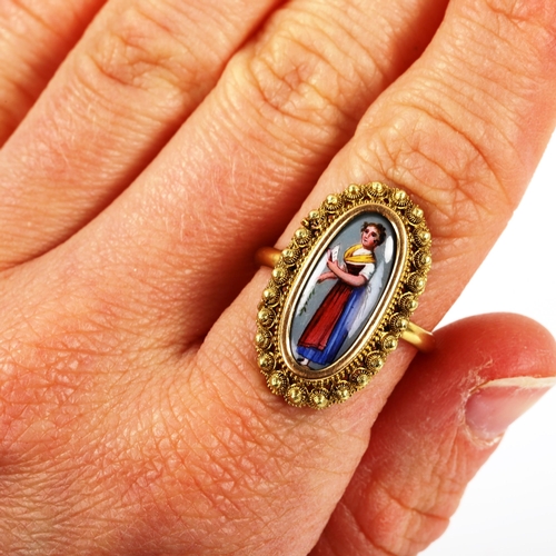 234 - An Antique 9ct gold miniature hand painted enamel panel ring, depicting lady with book, within canne... 