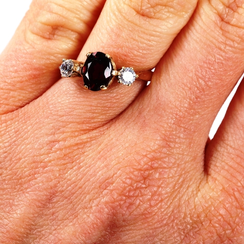 237 - A 9ct gold three stone garnet and cubic zirconia ring, setting height 8mm, size M, 2.8g