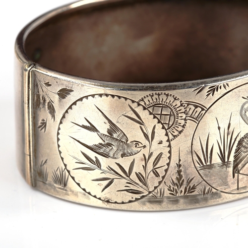 266 - A Victorian sterling silver chinoiserie style hinged bangle, engraved bird decoration, band width 26... 