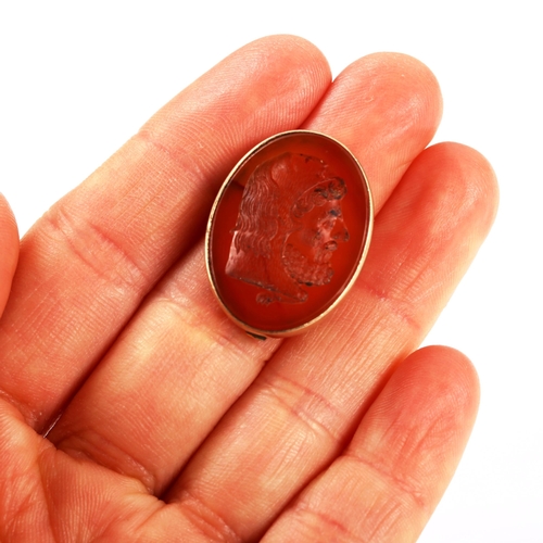 314 - An Antique carnelian seal fob brooch, intaglio carved with male head profile, in unmarked gold frame... 