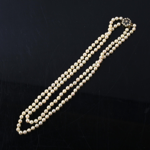 318 - A late 20th century double-strand pearl necklace, with 9ct gold sapphire and pearl clasp, necklace l... 